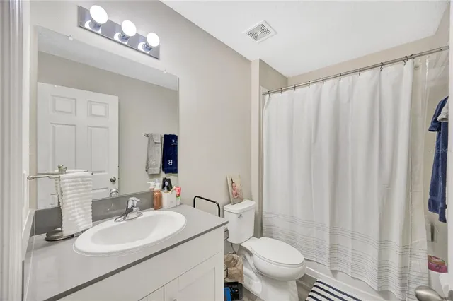 a bathroom with a sink vanity mirror and toilet