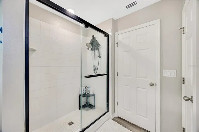 a bathroom with a glass shower door and a window