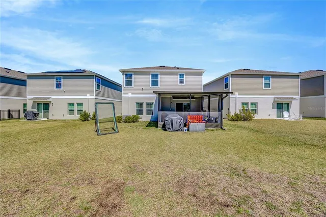 a view of a house with a backyard patio and a fire pit