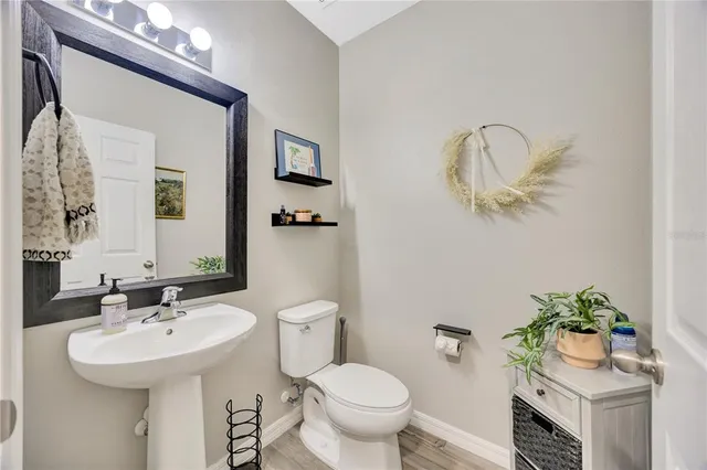 a bathroom with a sink toilet and a mirror