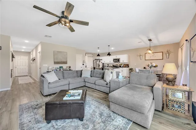 a living room with furniture and a view of kitchen