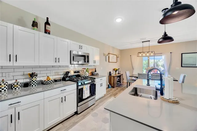 a kitchen with white cabinets and appliances