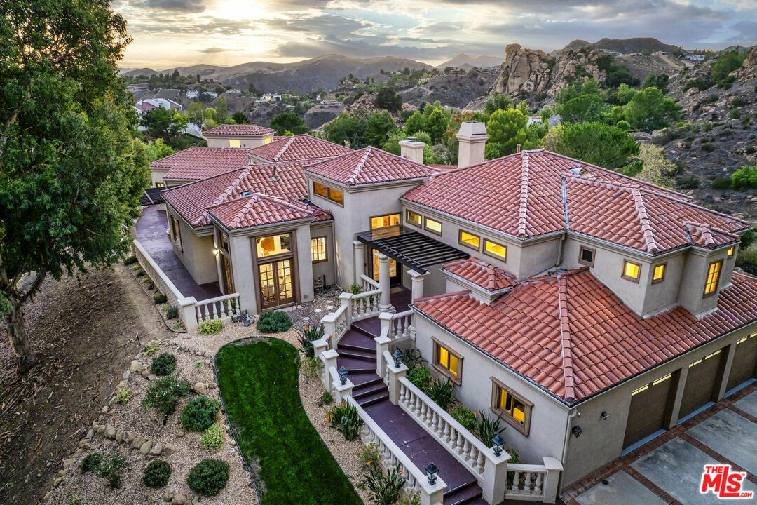 a aerial view of a house with a big yard plants and large tree
