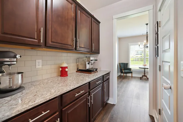 a kitchen with stainless steel appliances granite countertop a refrigerator a stove and a sink with wooden cabinets