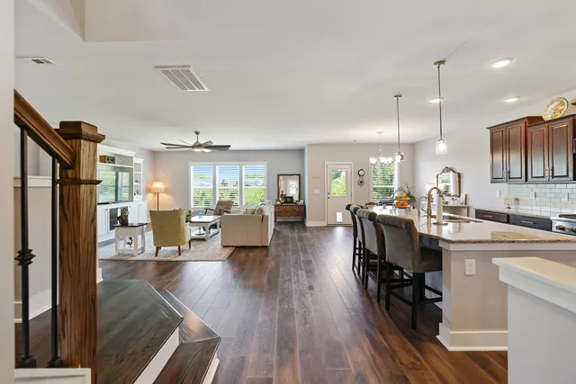 a living room with furniture flat screen tv and wooden floor