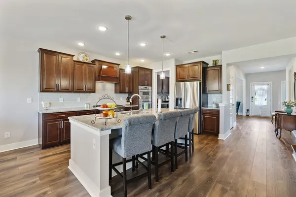 a living room with furniture a flat screen tv and kitchen view
