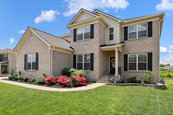 a front view of a house with yard and green space
