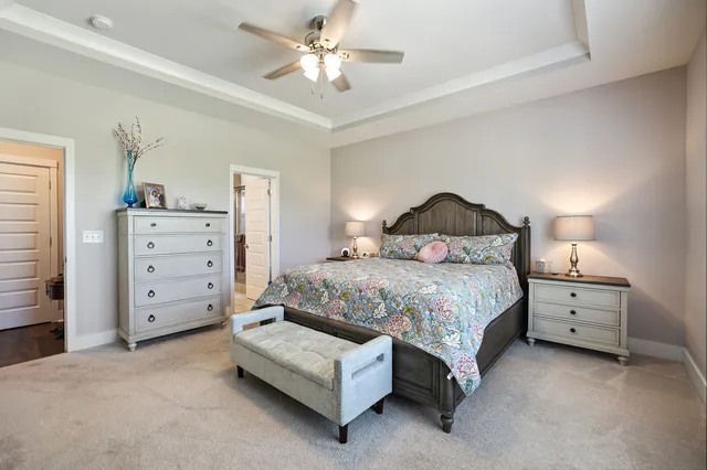 a bedroom with a bed and a lamp on the dresser