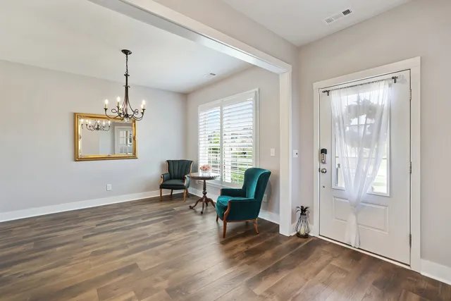 a kitchen with stainless steel appliances kitchen island granite countertop a dining table chairs refrigerator and microwave