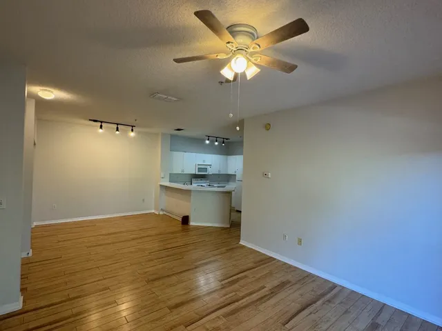 a view of a kitchen with wooden floor and a sink