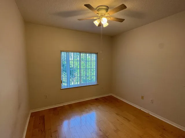 an empty room with a window and wooden floor