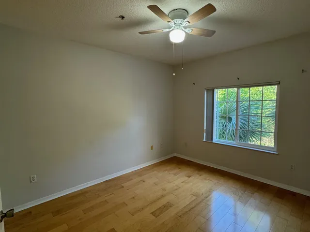 an empty room with a window and ceiling fan