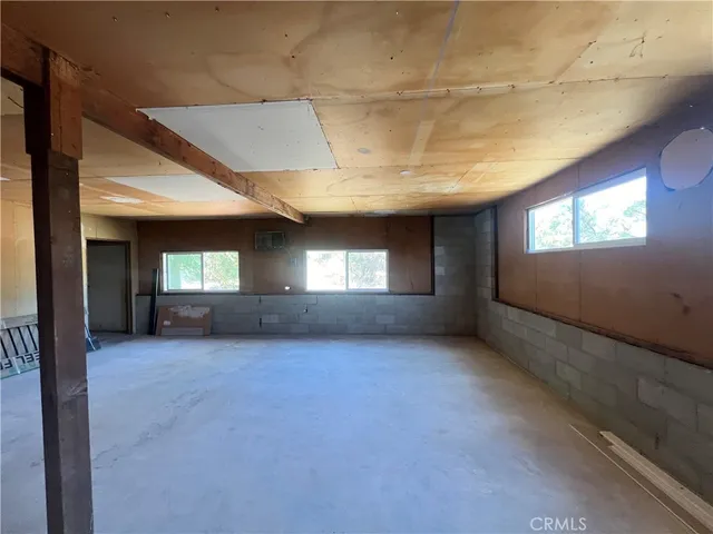 a view of an empty room with window and fireplace