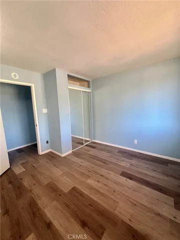 an empty room with wooden floor and closet