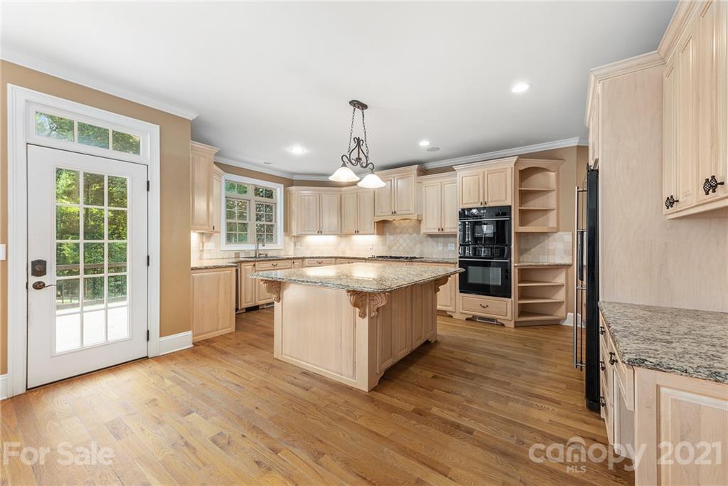 3268 Millstone Creek Road Lancaster, SC 29720 - Photo 6 of 35 a large kitchen with kitchen island wooden floors appliances and cabinets