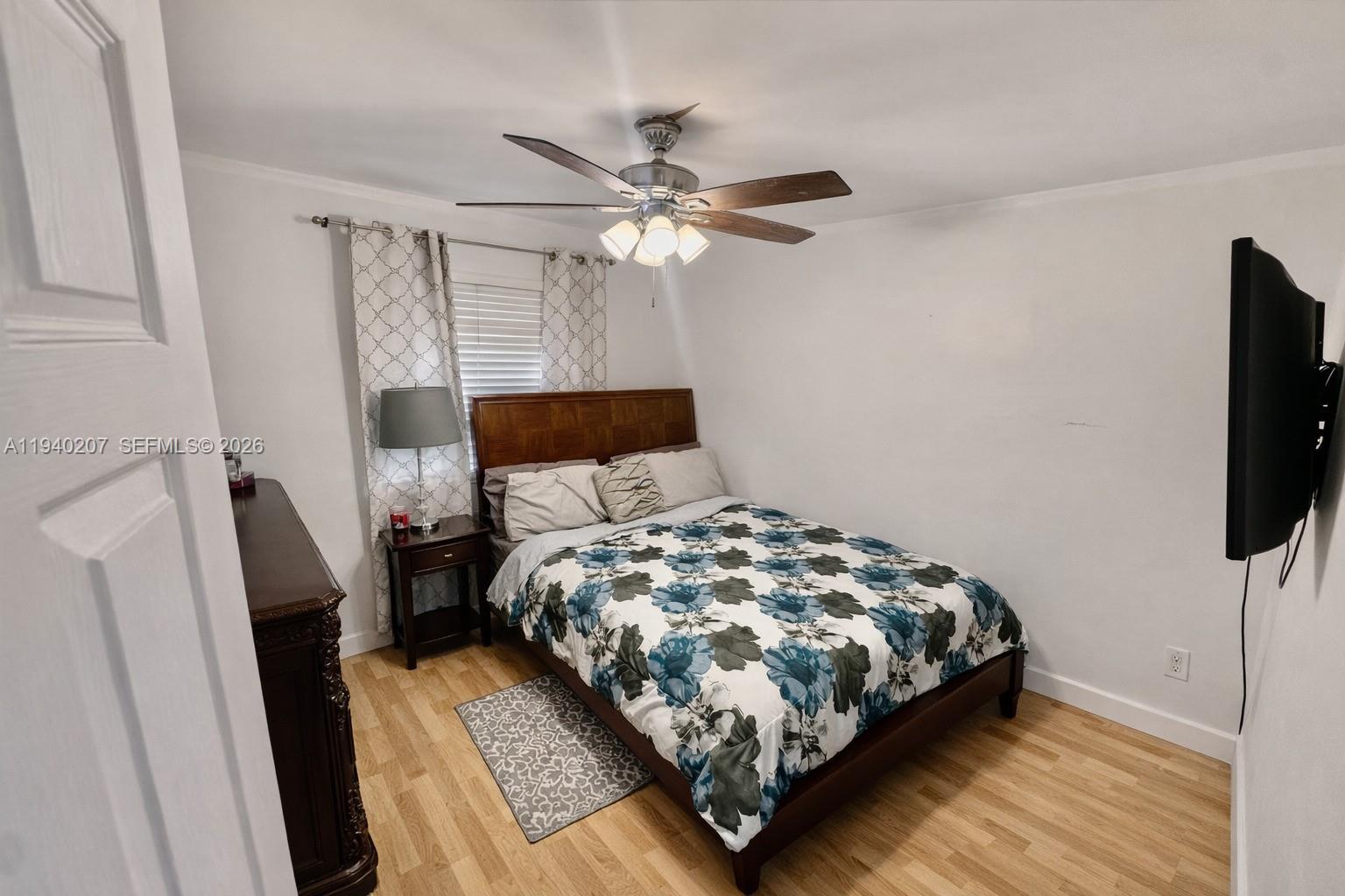 20125 Southwest 124th Avenue Miami, FL 33177 - Photo 7 of 21 a bedroom with a bed flat screen tv and a bookshelf