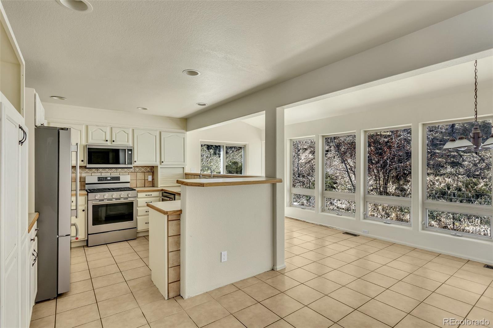 12183 Arnett Ranch Road Littleton, CO 80127 - Photo 7 of 28 a kitchen with stainless steel appliances a refrigerator sink and stove top oven
