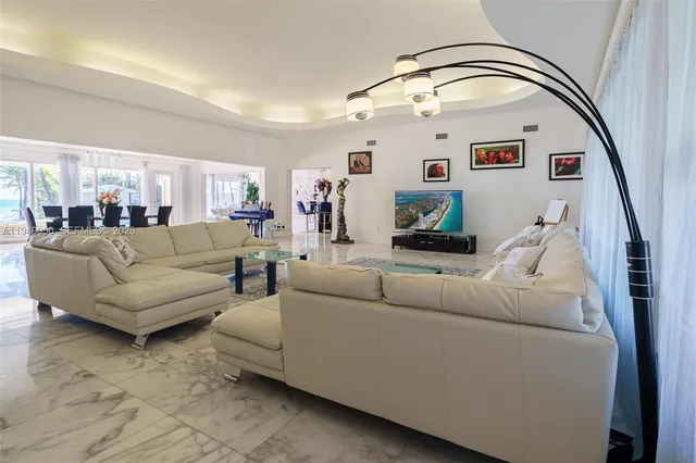 a view of a dining room and livingroom with furniture wooden floor a chandelier