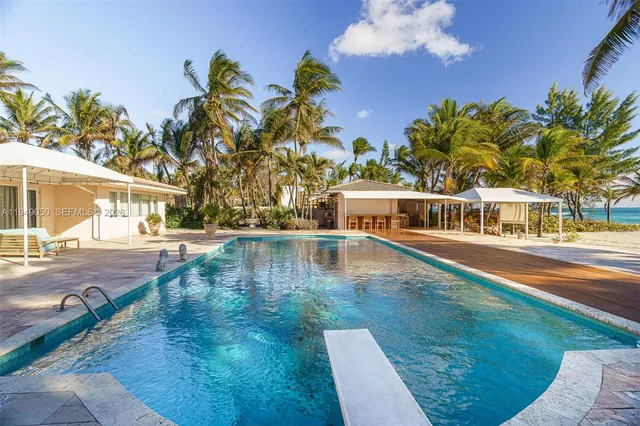 a front view of a house with yard and swimming pool