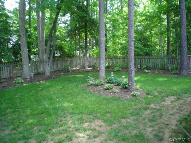 15004 Walnut Bend Road Midlothian, VA 23112 - Photo 10 of 10 a backyard of a house with lots of plants and large trees