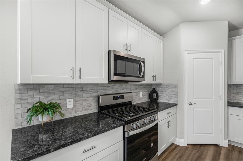 10508 Brookshire Road Fort Worth, TX 76126 - Photo 11 of 31 Kitchen featuring stainless steel appliances, dark stone countertops, tasteful backsplash, white cabinets, and dark wood-type flooring