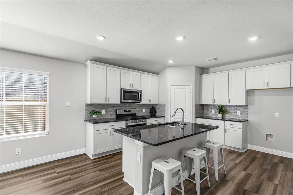 10508 Brookshire Road Fort Worth, TX 76126 - Photo 10 of 31 Kitchen with a kitchen breakfast bar, a kitchen island with sink, appliances with stainless steel finishes, white cabinets, and recessed lighting