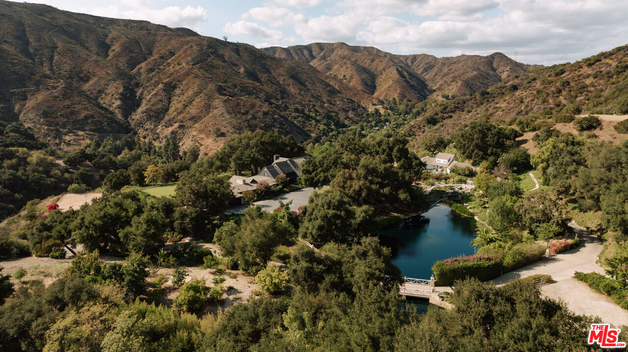 3100 Mandeville Canyon Road Los Angeles, CA 90049 - Photo 1 of 23 an aerial view of mountain with residential trees all around