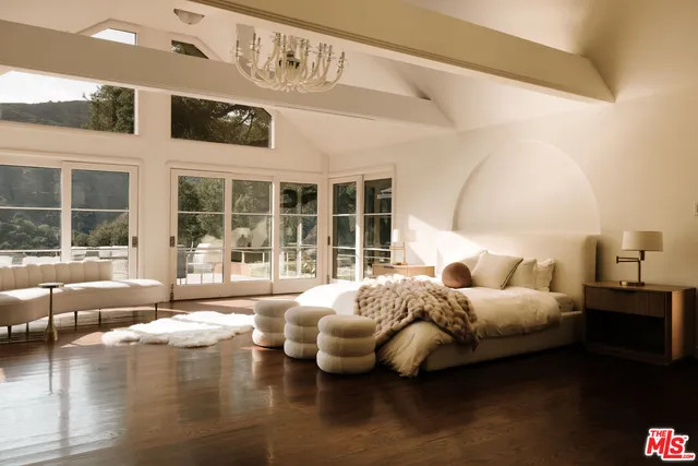 a bedroom with furniture and large windows