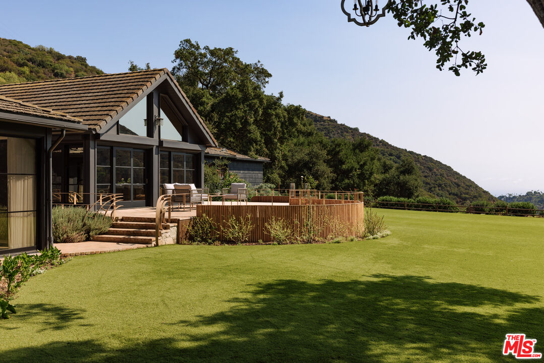 3100 Mandeville Canyon Road Los Angeles, CA 90049 - Photo 17 of 23 a view of a house with a swimming pool and a porch