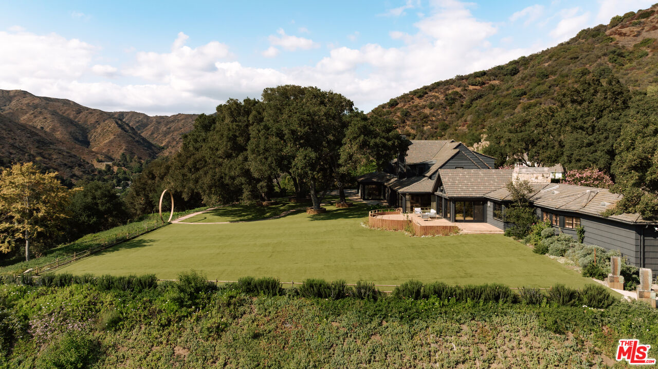 3100 Mandeville Canyon Road Los Angeles, CA 90049 - Photo 18 of 23 a view of a house with yard and mountain view
