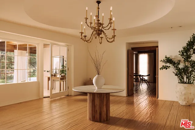 a view of a livingroom with wooden floor and a chandelier