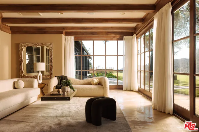 a living room with furniture and floor to ceiling windows