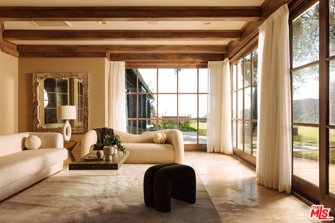 3100 Mandeville Canyon Road Los Angeles, CA 90049 - Photo 10 of 23 a living room with furniture and floor to ceiling windows