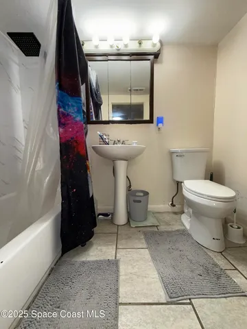 a living room with furniture a rug and a projector