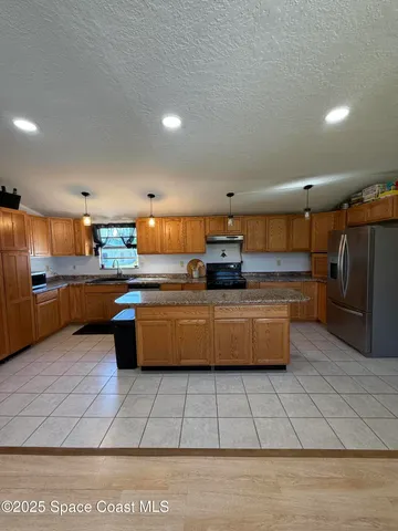 a large kitchen with stainless steel appliances lots of counter top space