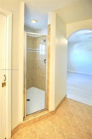 a bathroom with a glass shower door and a bathroom