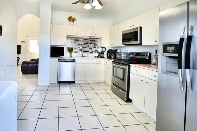 a kitchen with stainless steel appliances a refrigerator sink stove microwave and cabinets
