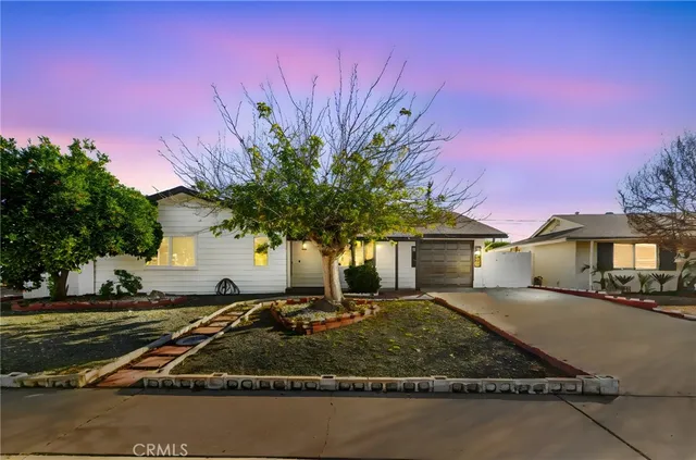 a front view of a house with a yard tree and a yard