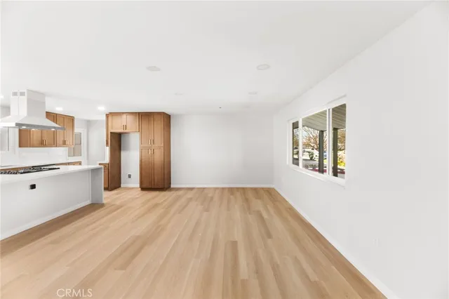a view of a kitchen with wooden floor and stainless steel appliances
