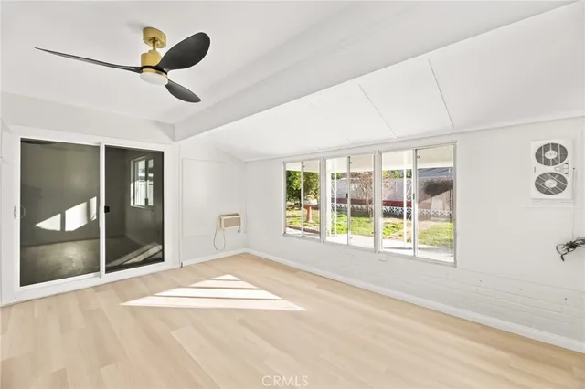 a view of an empty room with a window and a ceiling fan