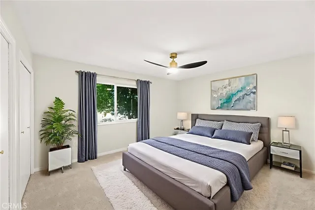 a bedroom with a large bed and a potted plant