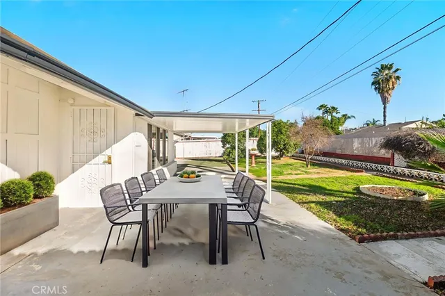 a view of a patio with a table and chairs under an umbrella