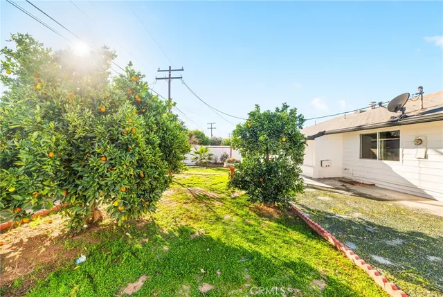 a view of a house with a big yard and large trees