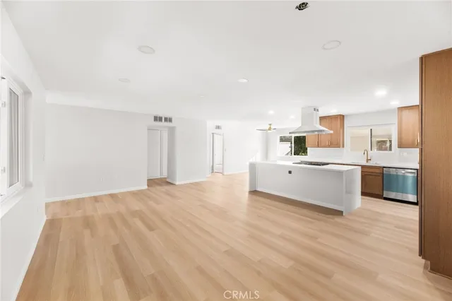 a large white kitchen with kitchen island a sink a stove and a refrigerator