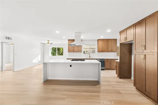 a view of kitchen with stainless steel appliances kitchen island wooden cabinets and refrigerator