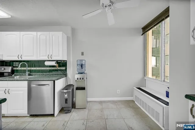 a kitchen with stainless steel appliances granite countertop a stove and a white cabinets