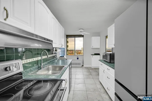 a kitchen with stainless steel appliances granite countertop a sink stove and cabinets