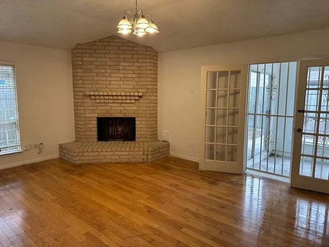 wooden floor fireplace and windows in an empty room