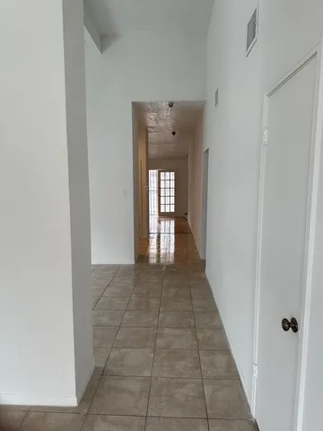 a view of a hallway with wooden floor and glass door