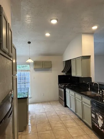 a kitchen with granite countertop a stove a sink and a microwave